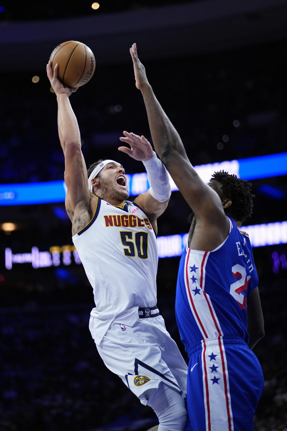 Denver Nuggets' Aaron Gordon, left, goes up for a shot against Philadelphia 76ers' Joel Embiid during the first half of an NBA basketball game, Tuesday, Jan. 16, 2024, in Philadelphia. (AP Photo/Matt Slocum)