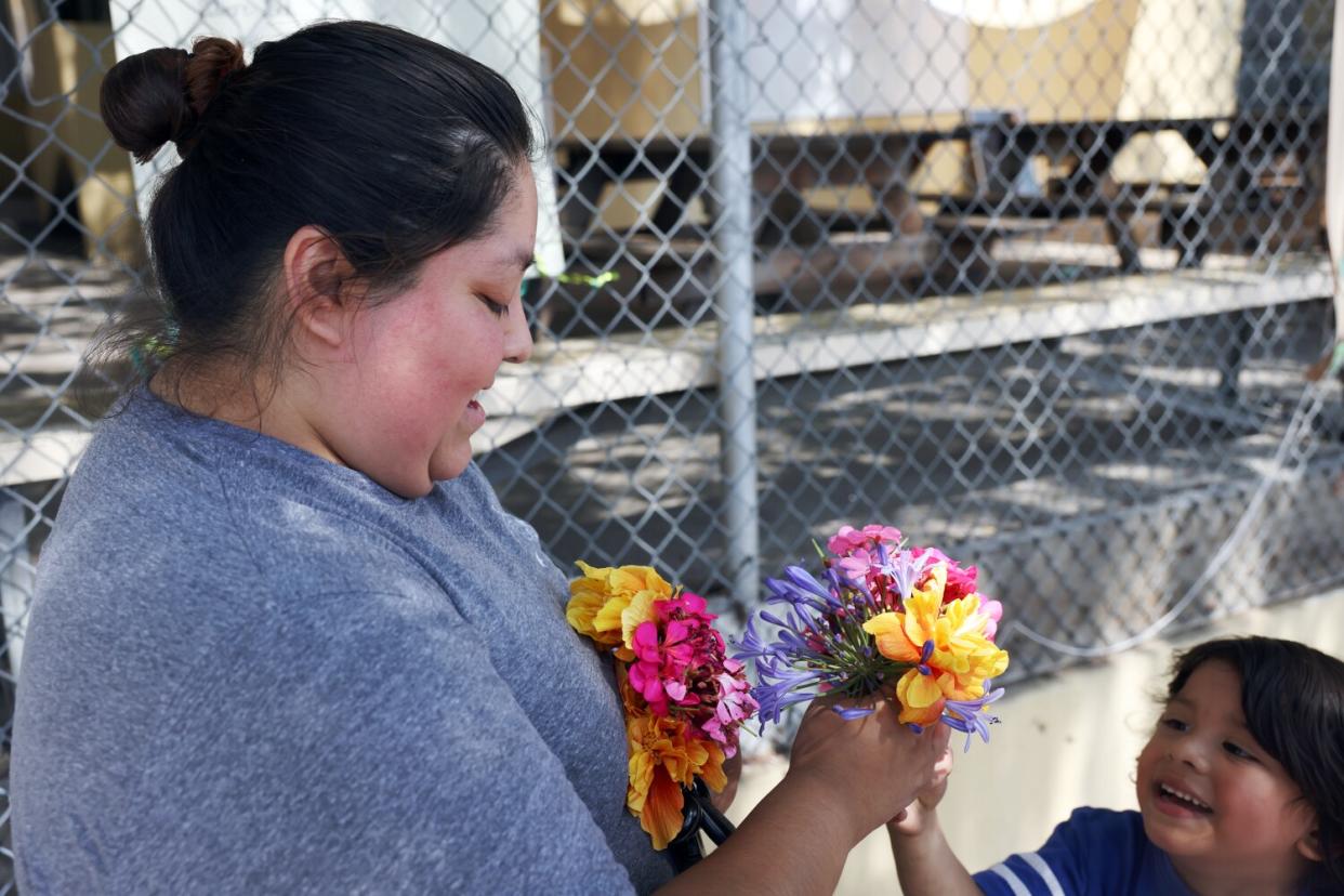 A mother receives flowers from her young son.