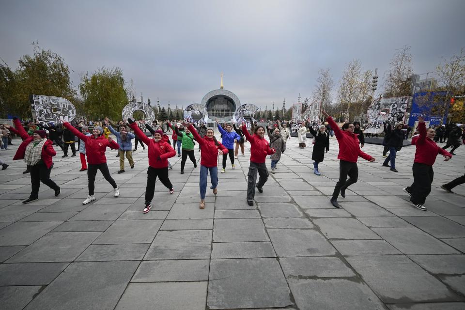 Volunteers perform during opening of the International exhibition "Russia" at VDNKh (The Exhibition of Achievements of National Economy) in Moscow, Russia, Saturday, Nov. 4, 2023. The vast show was put together under a decree from President Vladimir Putin and is seen as encouraging patriotism in the runup to the presidential election in March. (AP Photo/Alexander Zemlianichenko)