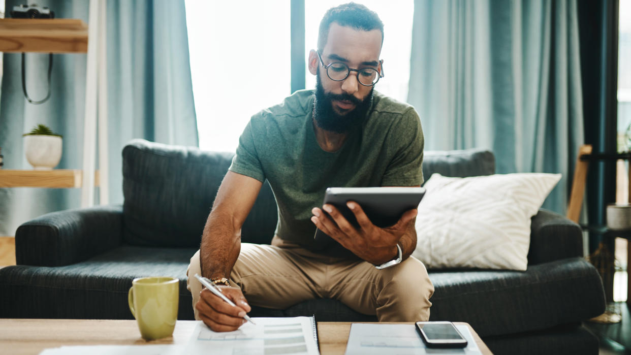 Shot of a young man going over his finances at home.