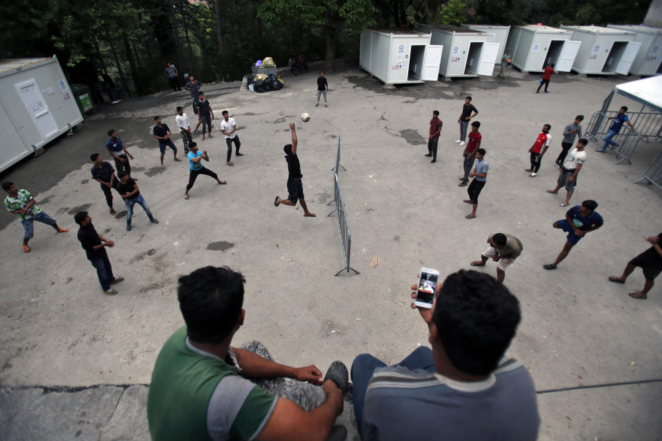 In this photo taken on Tuesday, Aug. 14, 2018, migrants play volleyball in a makeshift migrant camp in Bihac, 450 kms northwest of Sarajevo, Bosnia. Impoverished Bosnia must race against time to secure proper shelters for at least 4,000 migrants and refugees expected to be stranded in its territory during coming winter. The migrant trail shifted toward Bosnia as other migration routes to Western Europe from the Balkans were closed off over the past year. (AP Photo/Amel Emric)
