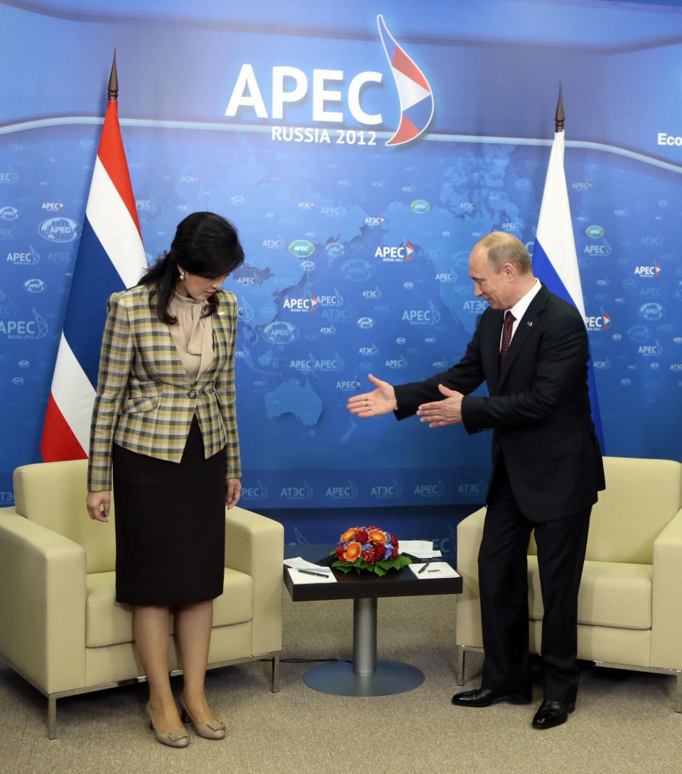 Russian President Vladimir Putin, guides Thai Prime Minister Yingluck Shinawatra to her chair during their meeting at the APEC summit in Vladivostok, Russia, Saturday, Sept. 8, 2012. (AP Photo/Mikhail Metzel, Pool)