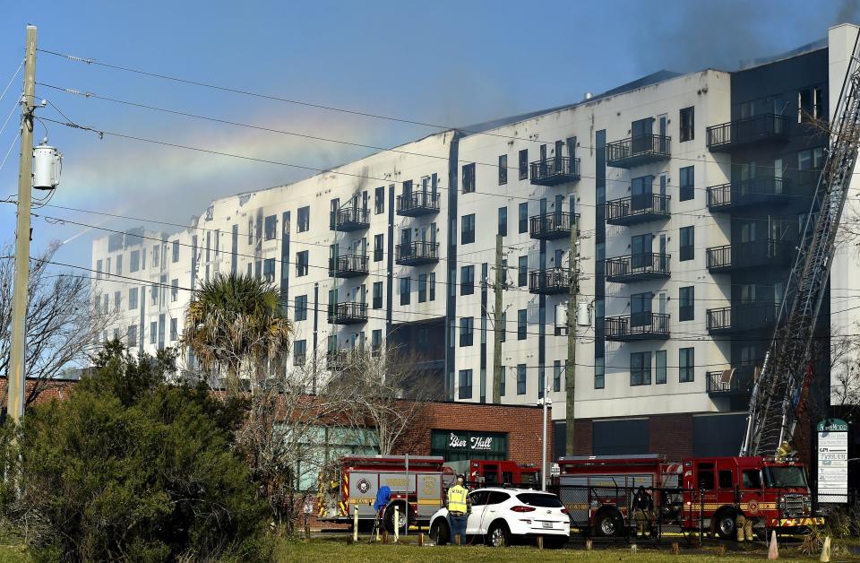 A rainbow forms in the spray of fire hoses trying to knock down the last of the hot spots in the fire-gutted RISE Doro apartment building Monday morning, Jan. 29, 2024. Crews worked through the night to contain the fire that burned through the under-construction complex on A. Philip Randolph Blvd. near the baseball stadium and the Veterans Memorial Arena.