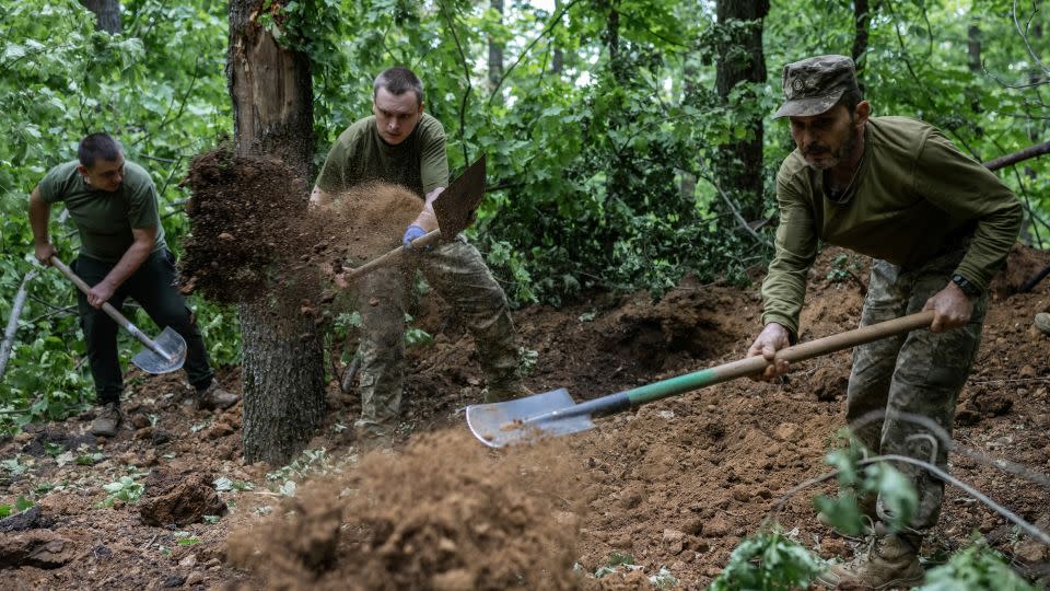 Ukrainian soldiers of the 42nd Separate Mechanized Brigade set up positions on the front line near Vovchansk on June 12, 2024. - Viacheslav Ratynskyi/Reuters