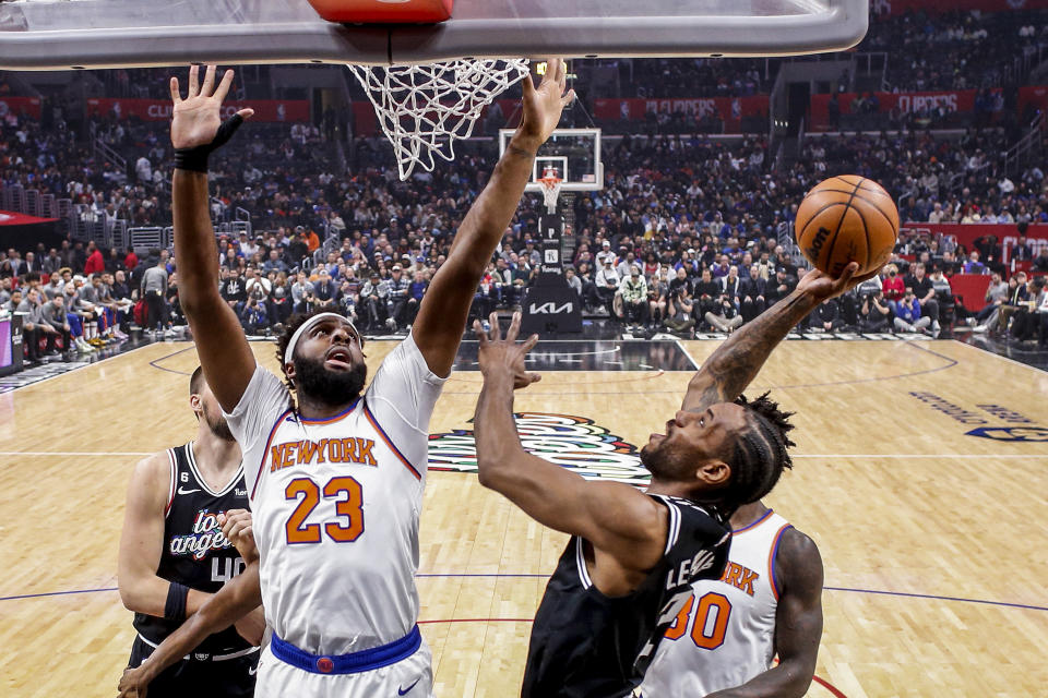 Los Angeles Clippers forward Kawhi Leonard, front right, shoots under pressure from New York Knicks center Mitchell Robinson (23) during the first half of an NBA basketball game Saturday, March 11, 2023, in Los Angeles. (AP Photo/Ringo H.W. Chiu)