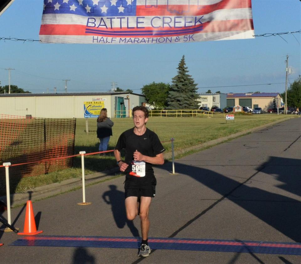 Jack Bidwell of Marshall wins the 5K portion of the 2022 Battle Creek Half Marathon after passing through the grounds of the Field of Flight on Saturday.