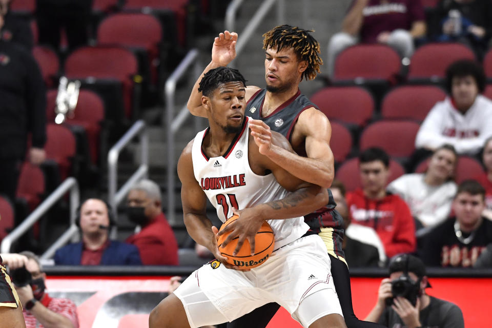 Louisville forward Sydney Curry (21) tries to get past Boston College forward T.J. Bickerstaff during the first half of an NCAA college basketball game in Louisville, Ky., Wednesday, Jan. 19, 2022. (AP Photo/Timothy D. Easley)