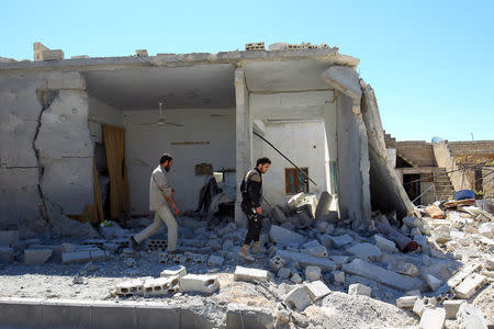 Civil defense members inspect the damage at a site hit by airstrikes on Tuesday, in the town of Khan Sheikhoun in rebel-held Idlib, Syria April 5, 2017. REUTERS/Ammar Abdullah