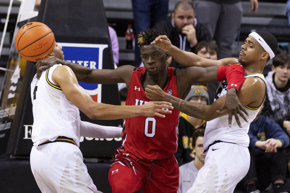 Utah's Lahat Thioune, center, fights off Missouri's Jarron Coleman, right, and Javon Pickett, left, during the second half of an NCAA college basketball game Saturday, Dec. 18, 2021, in Columbia, Mo. (AP Photo/L.G. Patterson)