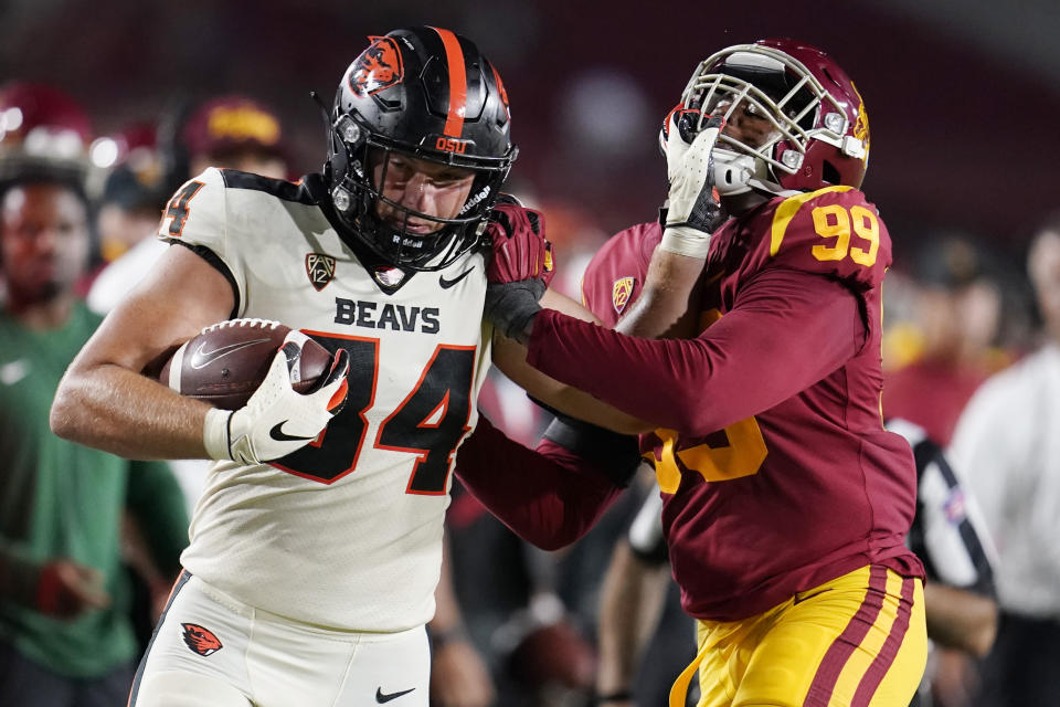 Oregon State tight end Teagan Quitoriano (84) stiff-arms Southern California linebacker Drake Jackson (99) after a reception during the second half of an NCAA college football game Saturday, Sept. 25, 2021, in Los Angeles. (AP Photo/Marcio Jose Sanchez)