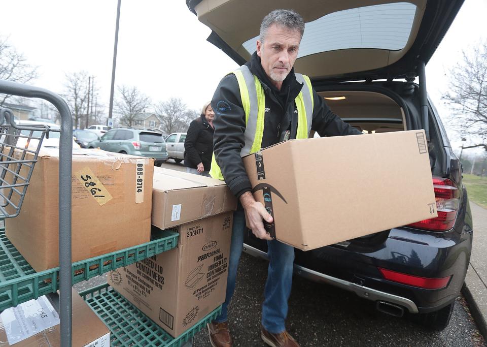Dominion employee Tony Bragg unloads a donor's car at the Southeast Community Center in Canton. For more than 30 years, Dominion Energy employees have adopted families identified through the A Community Christmas program and donated clothing, toys, household items, cleaning products all during the holidays.