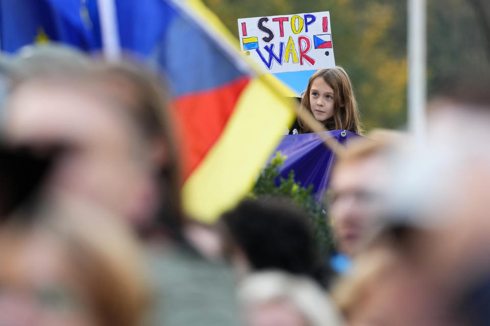 Young girl holds a sign as tens of thousands of people gathers for an anti-war protest in Prague, Czech Republic, Sunday, Oct. 30, 2022. (AP Photo/Petr David Josek)