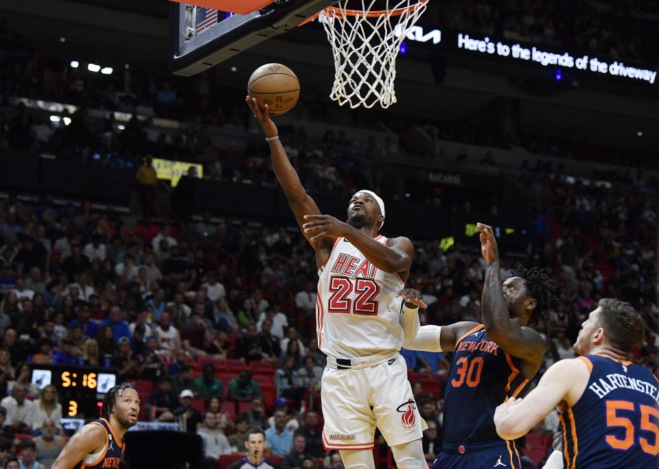 Miami Heat forward Jimmy Butler (22) scores on New York Knicks forward Julius Randle (30) during the second half of an NBA basketball game, Wednesday, March 22, 2023, in Miami, Fla. (AP Photo/Michael Laughlin)