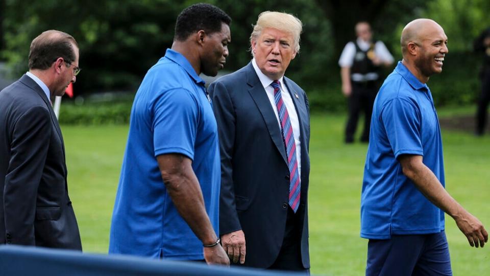 US President Donald Trump (Center-R), Herschel Walker (Center-L), Mariano Rivera (R), and Human Services Secretary Alex Azar, walk as they watch young participants during the White House Sports and Fitness Day on the South Lawn on May 30, 2018 in Washington, DC. (Photo by Oliver Contreras-Pool/Getty Images)