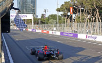 The checkered flag waves for Red Bull driver Sergio Perez of Mexico as he crosses the finish line to win the Formula One Grand Prix at the Baku Formula One city circuit in Baku, Azerbaijan, Sunday, June 6, 2021. (Maxim Shemetov, Pool via AP)