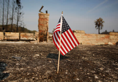 An American flag stands in front of a home destroyed after a wildfire tore through Santa Rosa, California, U.S., October 15, 2017. REUTERS/Jim Urquhart