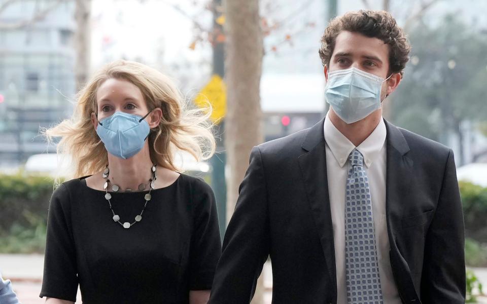 Former Theranos CEO Elizabeth Holmes, center, her partner Billy Evans, right, arrive at the Robert F. Peckham Federal Building and U.S. Courthouse in San Jose, Calif. - Tony Avelar/AP 