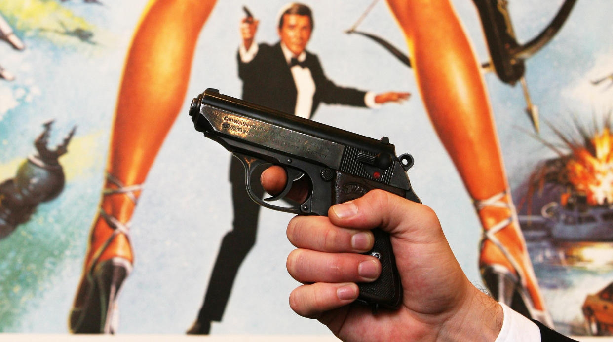 A Walther PPK handgun in front of a poster of the film 'For Your Eyes Only' at Christie's in London before the auction of a variety of weapons from James Bond films.   (Photo by Lewis Whyld - PA Images/PA Images via Getty Images)