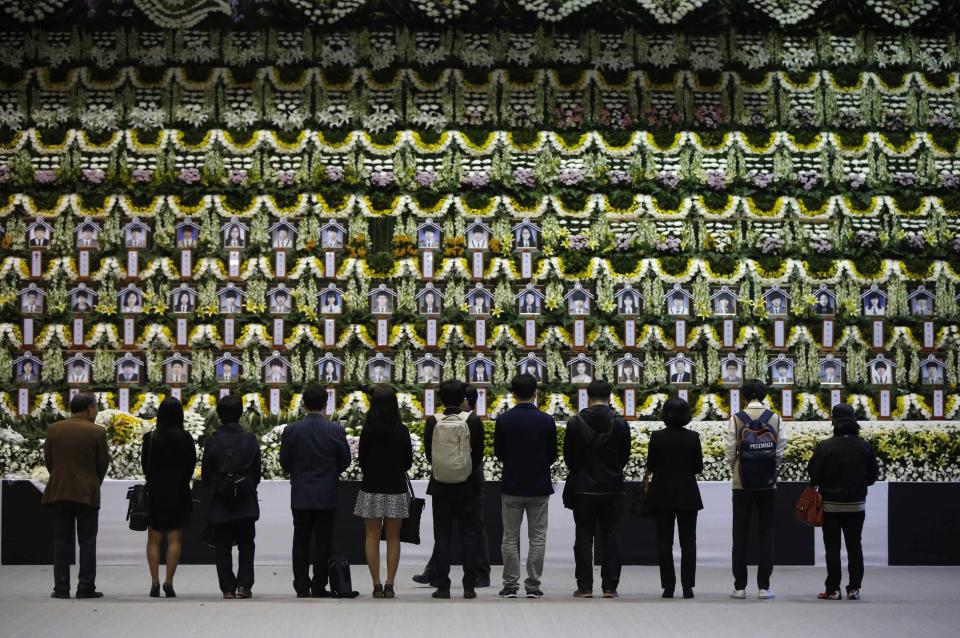 Mourners pay tribute in Ansan, at a temporary group memorial altar for victims of capsized passenger ship Sewol, April 25, 2014. A floral tribute to the children who drowned in the sinking South Korean ferry displays photographs of the victims in their school uniforms, while lines of empty spaces wait to be filled with photos once those still missing are confirmed dead. REUTERS/Issei Kato (SOUTH KOREA - Tags: DISASTER MARITIME TPX IMAGES OF THE DAY)