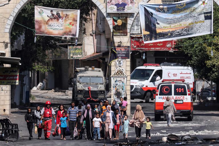 Personas huyen del campamento de refugiados de Yenín en Cisjordania ocupada durante una operación militar israelí en curso el 4 de julio de 2023.