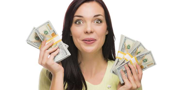 An excited looking woman holding up cash in each hand