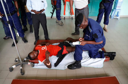 A protester, who was shot in the leg by police during a protest, talks to a policeman in a hospital in Kinshasa, Democratic Republic of Congo, February 25, 2018. REUTERS/Goran Tomasevic