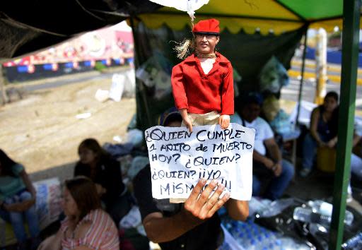 Un activista antigubernamental muestra un muñeco del fallecido presidente Hugo Chávez el 6 de marzo de 2014 en San Cristóbal, Venezuela (AFP | Leo Ramírez)