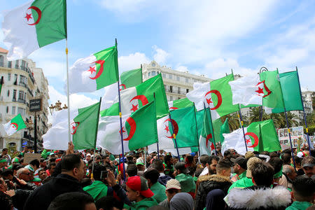 People carry national flags during a protest seeking the departure of the ruling elite, as the country prepares for presidential election in Algiers, Algeria April 12, 2019. REUTERS/Ramzi Boudina