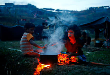 Rohingya refugee girl cooks a meal in an open place near Balukhali in Cox’s Bazar, Bangladesh, September 4, 2017. REUTERS/Mohammad Ponir Hossain