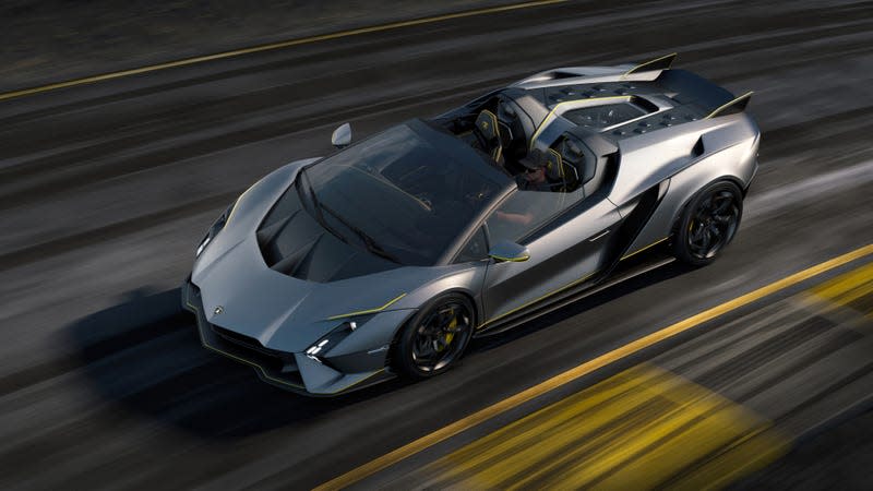 The gray Lamborghini Autentica roadster drives on-track, with the background image blurred with speed.