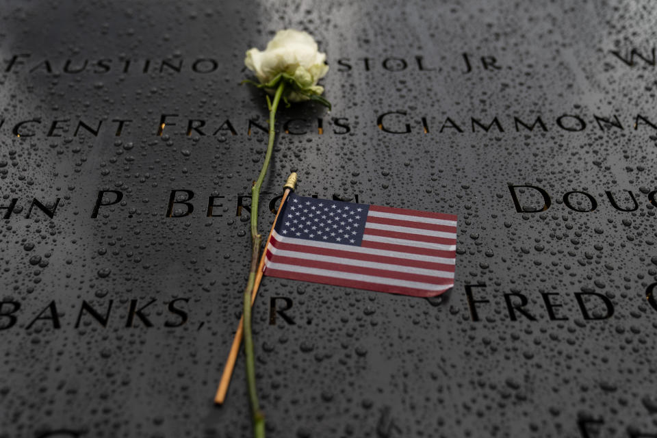 Flowers and American flags rest among the names of the fallen on the south pool at the National September 11 Memorial & Museum, Thursday, Sept. 9, 2021, in the Manhattan borough of New York. (AP Photo/John Minchillo)