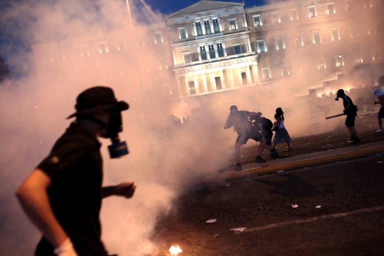 A protester clashes with riot police in front of the Greek Parliament in Athens on July 15, 2015