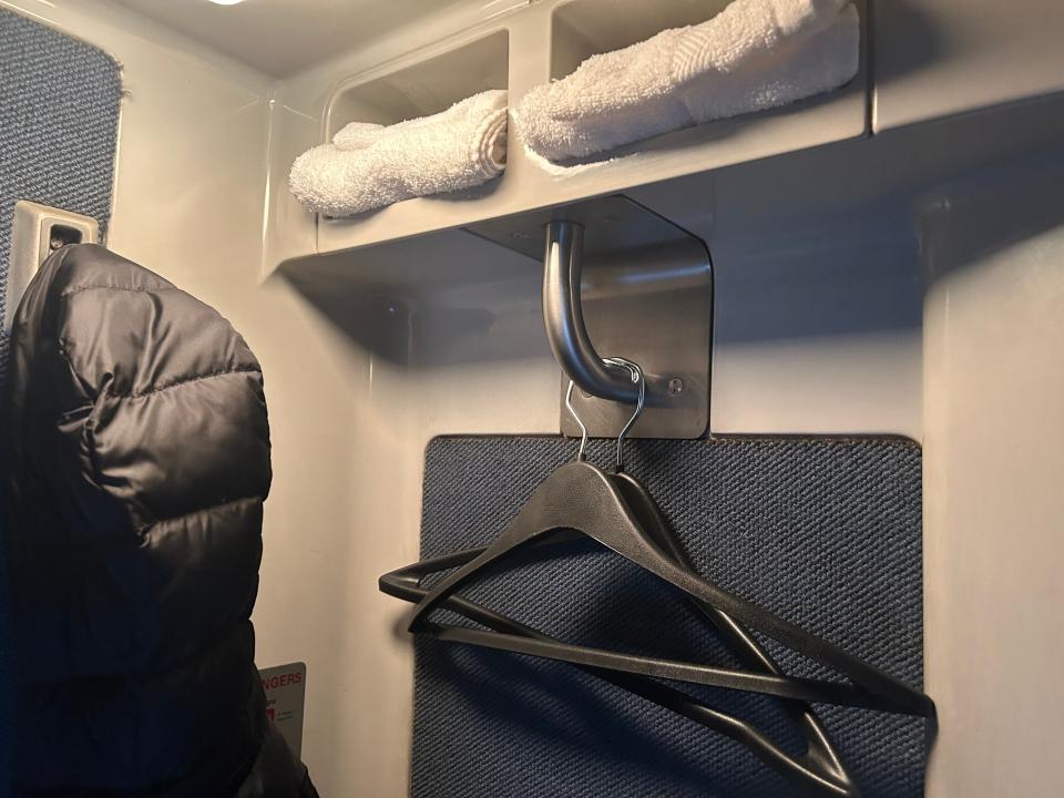 A coat and hangers inside an Amtrak roomette.