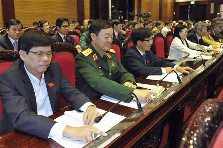 Vietnam's National Assembly's deputies press voting buttons to pass the new constitution during a meeting in Hanoi November 28, 2013. REUTERS/Stringer