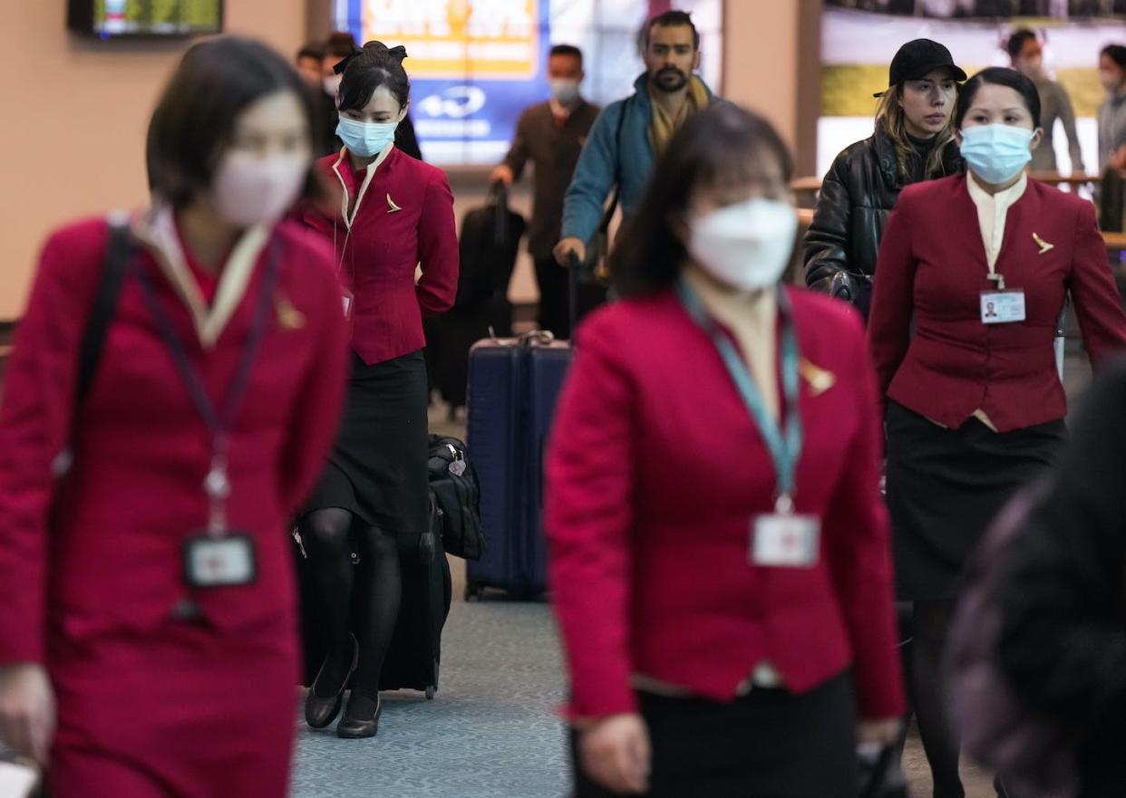 Cathay Pacific crew members who worked on a flight from Hong Kong arrive at Vancouver International Airport. Canada now requires air travellers from China, Hong Kong and Macau to have a recent negative COVID-19 test result. THE CANADIAN PRESS/Darryl Dyck