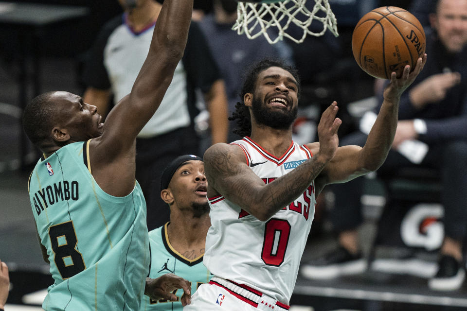 Chicago Bulls guard Coby White (0) tries to shoot while guarded by Charlotte Hornets center Bismack Biyombo (8) during the second half of an NBA basketball game in Charlotte, N.C., Friday, Jan. 22, 2021. (AP Photo/Jacob Kupferman)