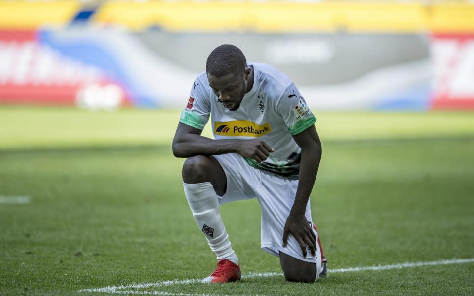 Marcus Thuram of Borussia Moenchengladbach takes a knee after scoring a goal for his team in a Bundesliga match - Christian Verheyen/Borussia Moenchengladbach