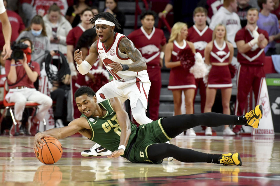 Charlotte guard Clyde Trapp (0) dives for a loose ball in front of Arkansas guard Chris Lykes (11) during the first half of an NCAA college basketball game Tuesday, Dec. 7, 2021, in Fayetteville, Ark. (AP Photo/Michael Woods)