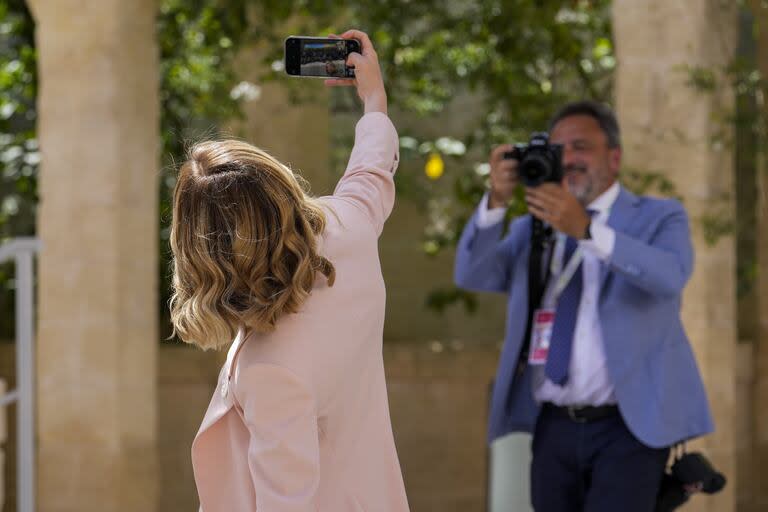 La primera ministra italiana, Giorgia Meloni, se toma una selfie con los medios mientras espera a los líderes mundiales durante una cumbre del G7 