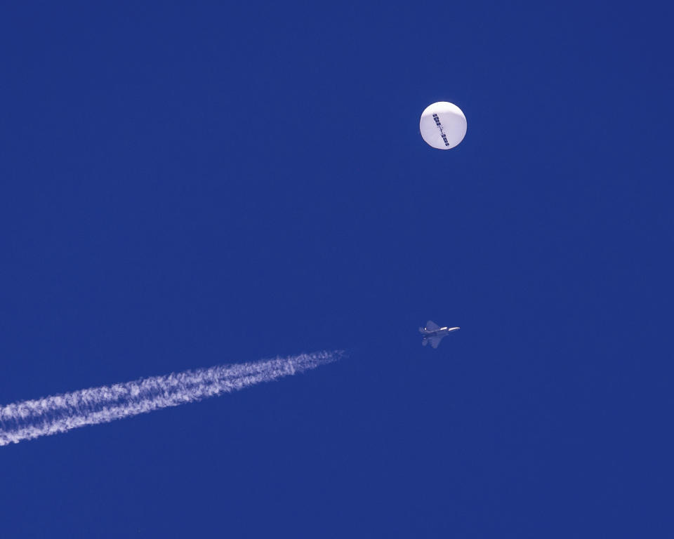 FILE - In this photo provided by Chad Fish, a large balloon drifts above the Atlantic Ocean, just off the coast of South Carolina, with a fighter jet and its contrail seen below it, Saturday, Feb. 4, 2023. U.S. officials say the military has finished efforts to recover the remnants of the large balloon that was shot down off the coast of South Carolina, and analysis of the debris so far reinforces conclusions that it was a Chinese spy balloon. (Chad Fish via AP, File)