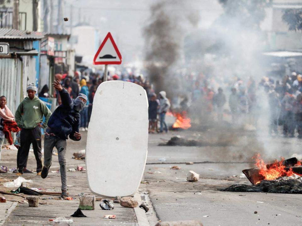 Residents of Masiphumelele throw rocks at police amidst an ongoing strike by taxi operators (REUTERS/Nic Bothma)