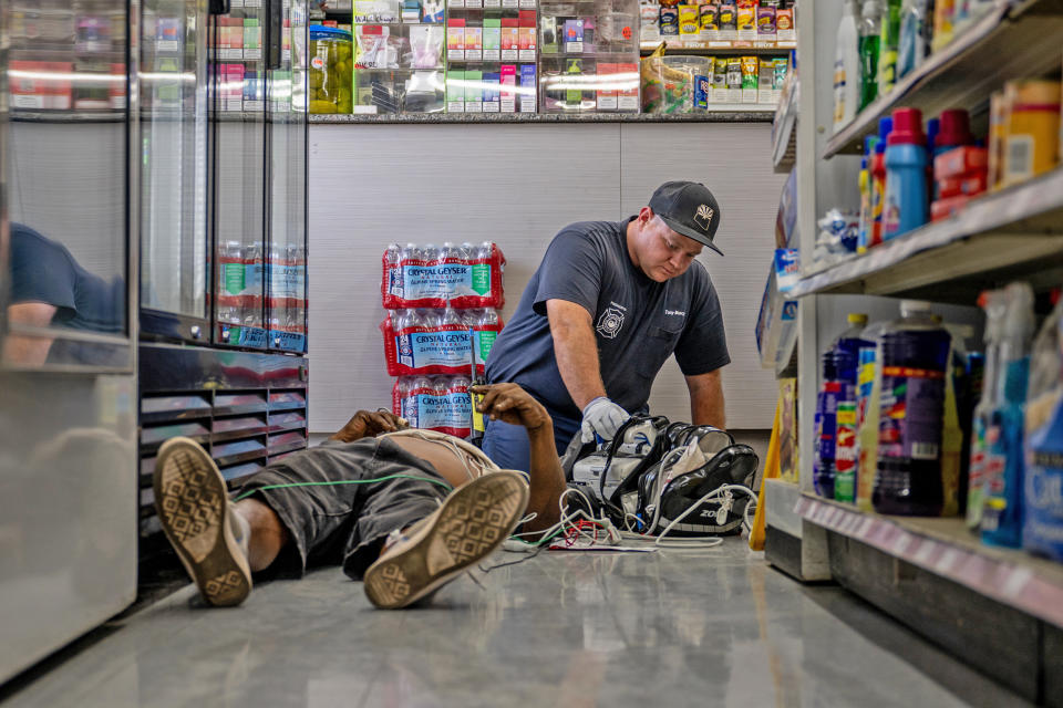 A person receives medical attention after collapsing in a convenience store on July 13, 2023 in Phoenix. EMT was called after the person said they experienced hot flashes, dizziness, fatigue and chest pain.  (Brandon Bell / Getty Images)