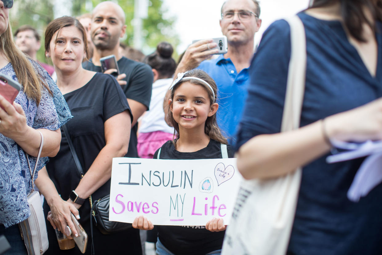 A girl holds a sign that reads "Insulin Saves My Life" while Democratic presidential candidate, U.S. Sen. Bernie Sanders talks about the cost of insulin in the USA versus Canada as he joins a group of people with diabetes on a trip to Canada for affordable Insulin on July 28, 2019 in Windsor, Canada. (Photo by Scott Eisen/Getty Images)