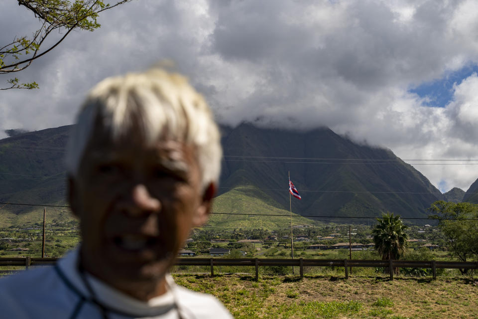 The Hawaiian flag flies in the background, as Abraham "Snake" Ah Hee talks about the stories his great-grandmother told him when grew up at Launiupoko Beach Park on Friday, Feb. 23, 2024, in Lahaina, Hawaii. (AP Photo/Mengshin Lin)