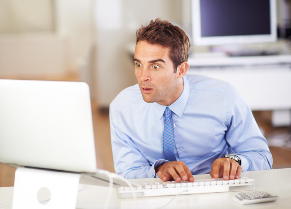 A man looking at his computer monitor with his mouth agape.