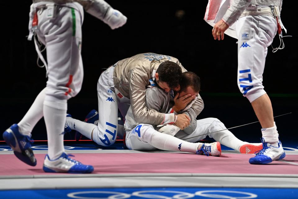 <p>Italy's Luca Curatoli (C) celebrates with his teammates after scoring the final point against Hungary's Aron Szilagyi compete against in the men's sabre team semifinal bout during the Tokyo 2020 Olympic Games at the Makuhari Messe Hall in Chiba City, Chiba Prefecture, Japan, on July 28, 2021. (Photo by Mohd RASFAN / AFP)</p> 