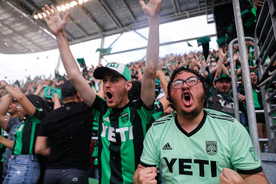 Austin FC fans Travis Scarangello, right, and Walker Pyle, left, cheer as Austin FC scored their fourth goal against Inter Miami CF at Q2 Stadium in Austin, Texas on March 6, 2022.