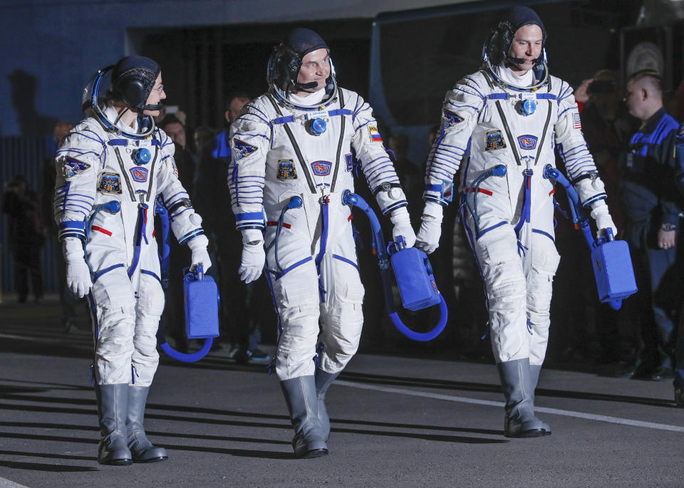 U.S. astronauts Christina Hammock Koch, left, Nick Hague, right, and Russian cosmonaut Alexey Ovchinin, members of the main crew of the expedition to the International Space Station (ISS), walk prior the launch of Soyuz MS-12 space ship at the Russian leased Baikonur cosmodrome, Kazakhstan, Thursday, March 14, 2019. (AP Photo/Dmitri Lovetsky, Pool)