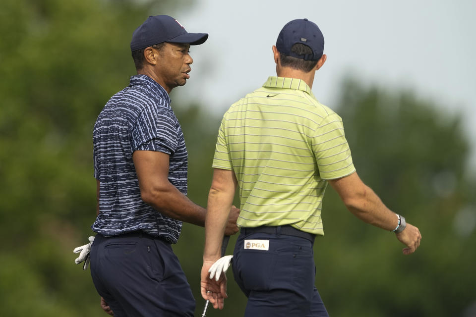Tiger Woods and Rory McIlroy, of Northern Ireland, walk on the 13th hole during the first round of the PGA Championship golf tournament Thursday, May 19, 2022, in Tulsa, Okla. (AP Photo/Matt York)