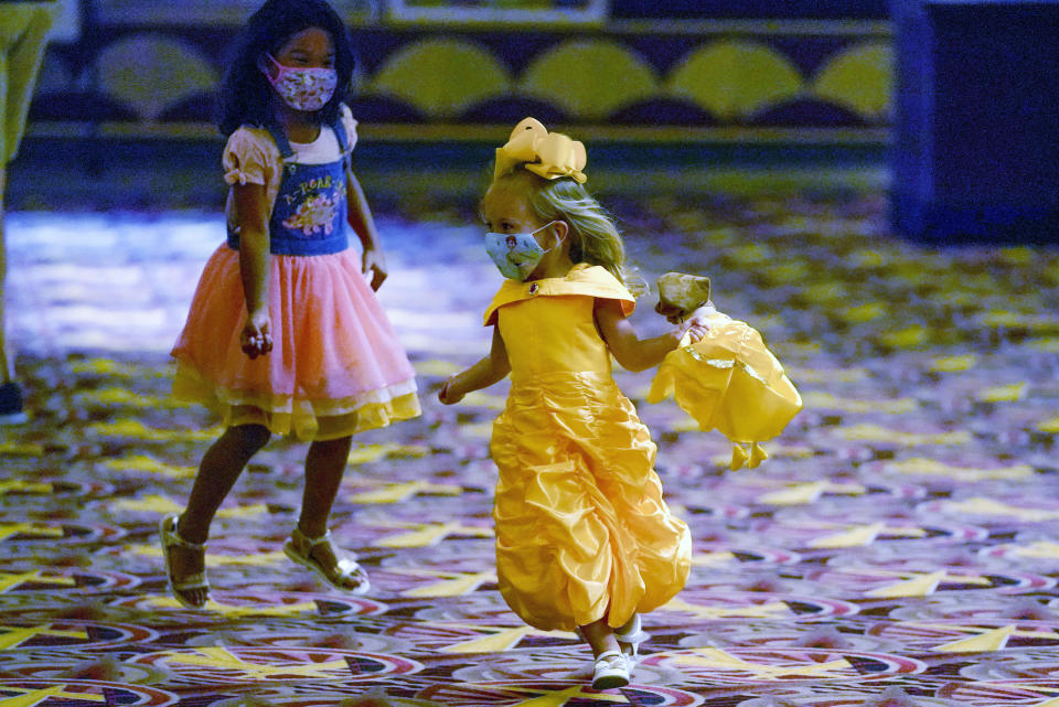 Emely Frahis, 5, chases three-year-old Lilly Stevenson, right, around the lobby as they wait to go into the theatre to see "Beauty and the Beast", of the first showings at the AMC theatre when it re-opened for the first time since shutting down at the start of the COVID-19 pandemic, Thursday, Aug. 20, 2020, in West Homestead, Pa. (AP Photo/Keith Srakocic)